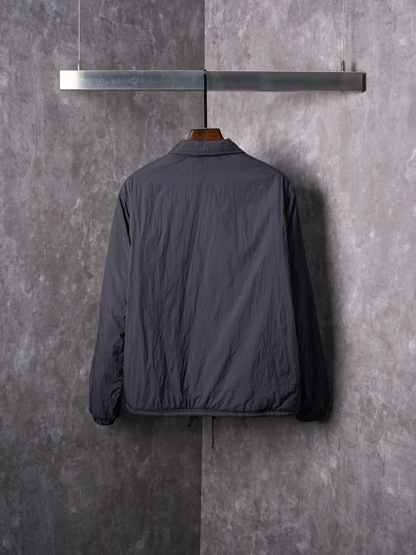 P640 Actual auction] Ralph Lauren/Ralph Lauren Pony Red Label lightweight cotton lapel coach jacket [Ready stock] S M L XL Material: high-density nylon taffeta Features: Density is about 210T-300T, smooth and slightly matte surface, excellent windproof and waterproof performance (with DWR water-repellent treatment), strong wrinkle resistance and easy care, in line with the positioning of American casual "durable and practical".  Color: Classic dark black, using vat dyeing process (dye penetrates into the fiber), the color fastness reaches ISO level 4 or above to avoid fading or color transfer after washing.  2. Lining fabric Material: Lightweight cotton-polyester blended lining (65% Polyester + 35% Cotton) Function: Reduce friction between the fabric and inner clothing, improve wearing smoothness; blended material has both breathability and durability to avoid the stuffy feeling of pure nylon lining.  Version and cutting process Version: Classic Coach Jacket, loose version, slightly dropped shoulder line (shoulder width is 1-2cm wider than the standard version), length to the hips, and slightly tapered straight sleeves, taking into account both freedom of movement and casual style. Embroidery technology: Polo horse logo on the left chest: flat satin stitch embroidery (satin embroidery), embroidery thread: 100% polyester high color fastness embroidery thread (the color number is consistent with the brand’s standard red color card), stitch density 12-15 stitches/cm, the outline of the horse logo is clear, and the details of the rider and horse are burr-free.  Embroidery positioning: precise positioning through the template (12cm from the neckline and 8cm from the placket) to ensure left and right symmetry and centering.  Topstitching technology: The seams of the body are made of double-needle flat seams (needle pitch 3cm/10 needles), the stitches are smooth and straight, the stitching color is dark black (the same color as the fabric), and the stitch width is 0.5cm, which enhances firmness while forming simple decorative lines.  1. Main body splicing, splicing of the front placket and body: The placket is made of double-layer folding + flat seam splicing, with a thickness of about 0.3cm to ensure that the buttons are not easily deformed when fixed; the edges of the placket are cut with a hot knife to avoid burrs.  Sleeve panels are spliced ​​to the body: the armholes are spliced ​​with round-head keyhole machine seams + flat seams. After splicing, the armholes have a natural curvature and no sense of tightness during movement; the height of the sleeves is about 8-10cm, which is in line with the loose characteristics of casual jackets.  Main button: black urea resin button, matte surface treatment, buttonholes are hand-made keyholes (6 strands of cotton thread, keyhole density 8 stitches/mm), the edges of the eyelets are smooth and without burrs.  Collar buttons: The first button on the collar is a hidden button (diameter 12mm), which prevents the collar from opening and improves the neatness of wearing.